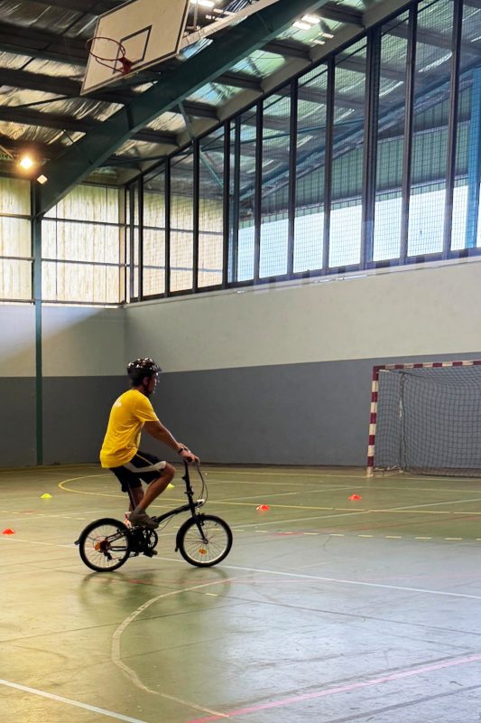 Un cycliste sur un vélo-pliant dans un gymnase